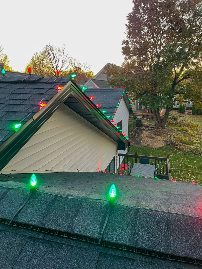 Red and green Christmas bulbs installed along roof peaks